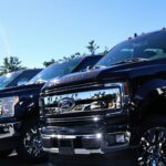 Lineup of new Ford pickup trucks at dealership lot