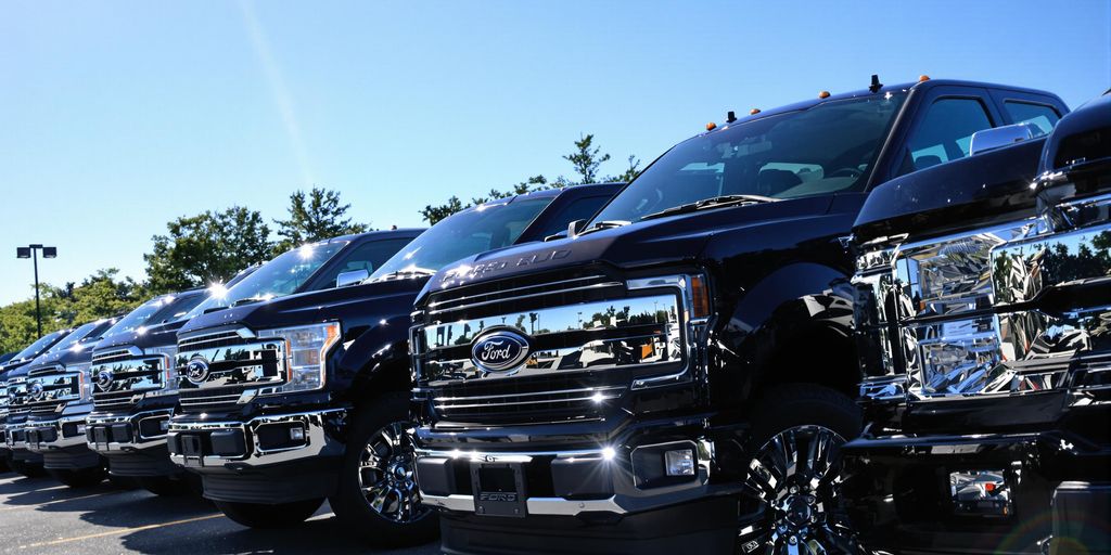 Lineup of new Ford pickup trucks at dealership lot