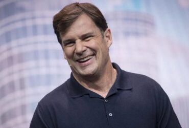 Jim Farley in a polo shirt on stage.