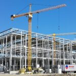 Electric vehicle factory construction with Rivian trucks nearby