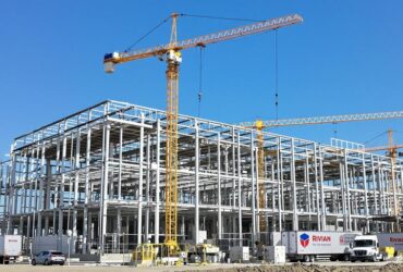Electric vehicle factory construction with Rivian trucks nearby