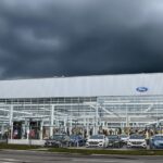 Ford factory with dark clouds and parked cars