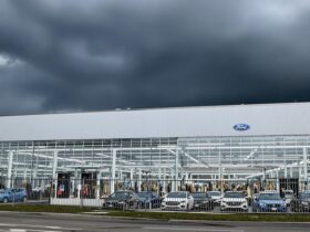Ford factory with dark clouds and parked cars