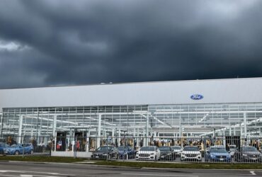 Ford factory with dark clouds and parked cars