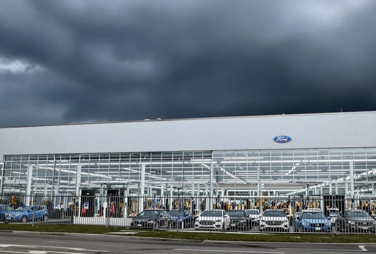 Ford factory with dark clouds and parked cars