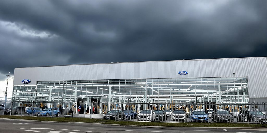 Ford factory with dark clouds and parked cars